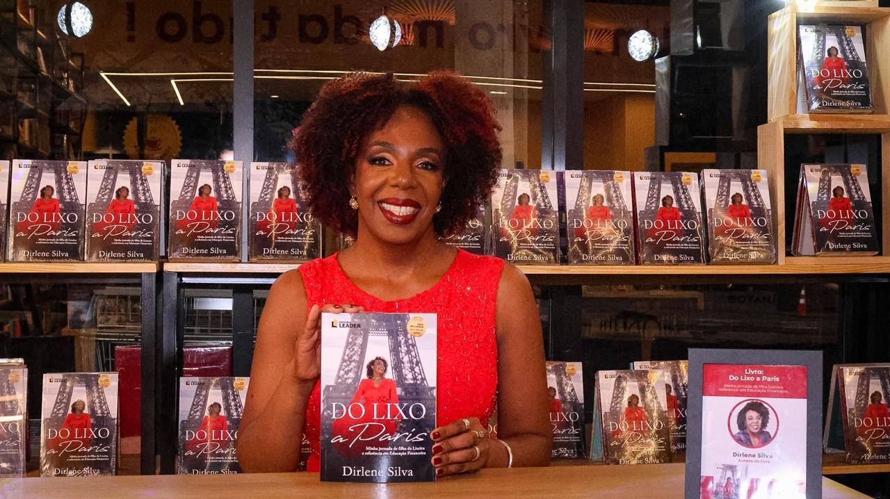 Dirlene Silva segurando o livro Do lixo a Paris